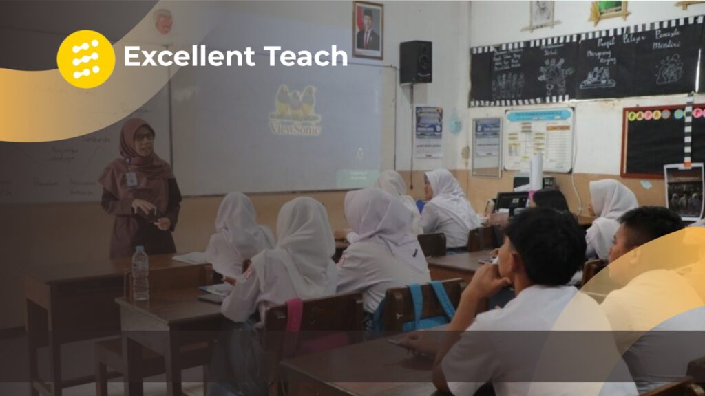 Suasana pembelajaran di ruang kelas, dengan seorang guru berdiri di depan siswa yang sedang mengikuti kegiatan belajar. Di bagian atas terdapat logo dan tulisan ‘Excellent Teach’